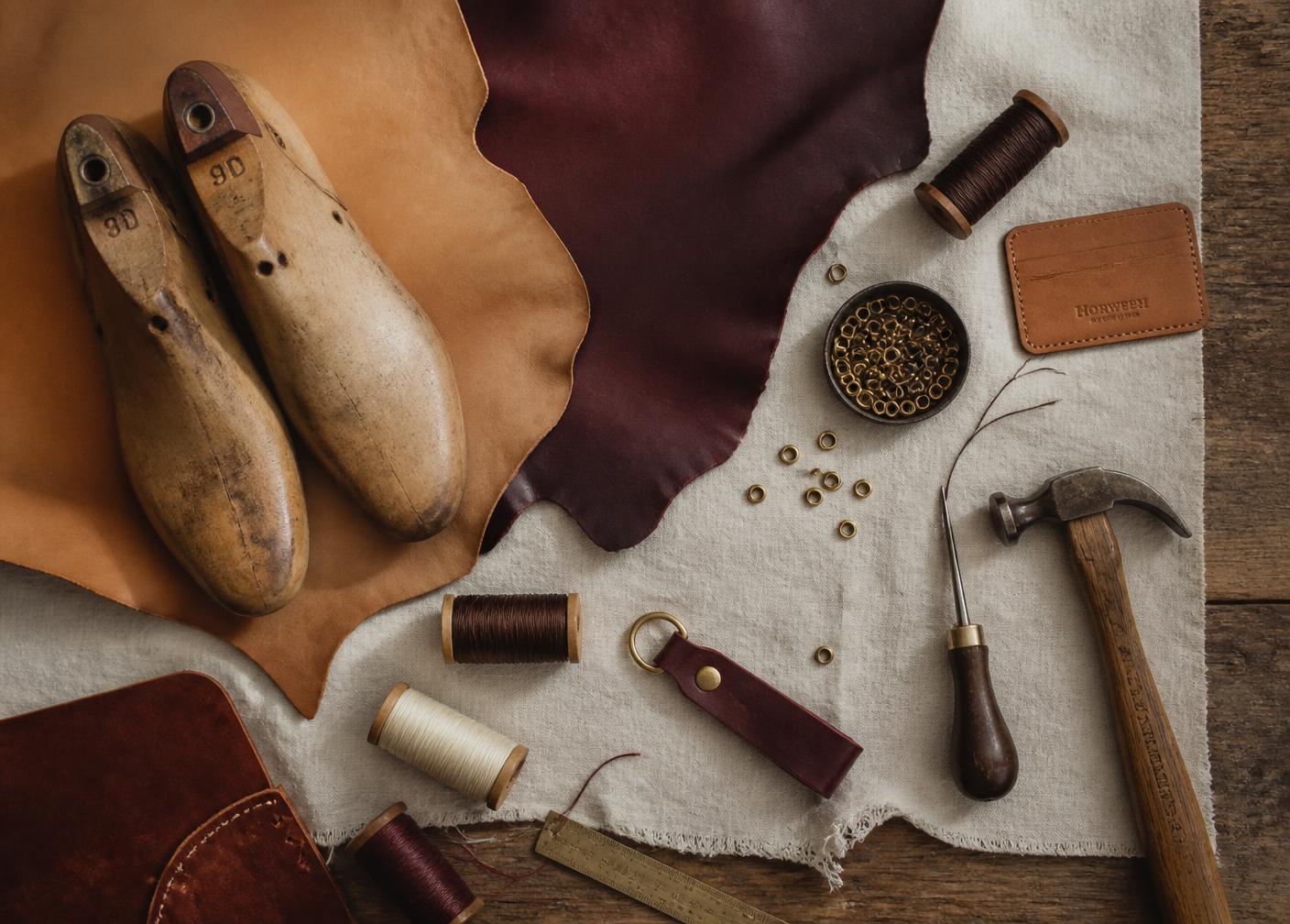 Leather hides, wooden lasts, waxed thread and hand tools on a workbench